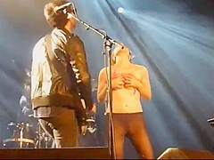 Audience girl strips on stage during a concert